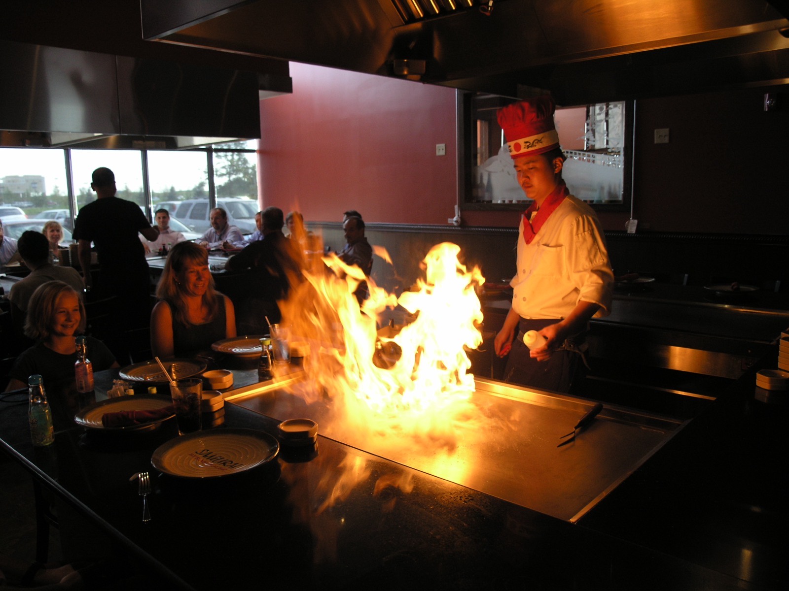 Hibachi chef cooking with fire at a table-side teppanyaki grill at Samurai Sushi and Hibachi